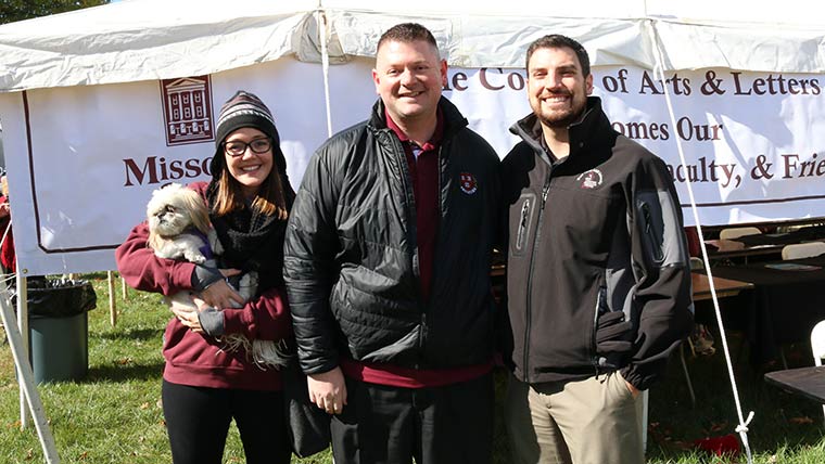 Alumni couple with College of Arts and Letters dean Shawn Wahl at homecoming.